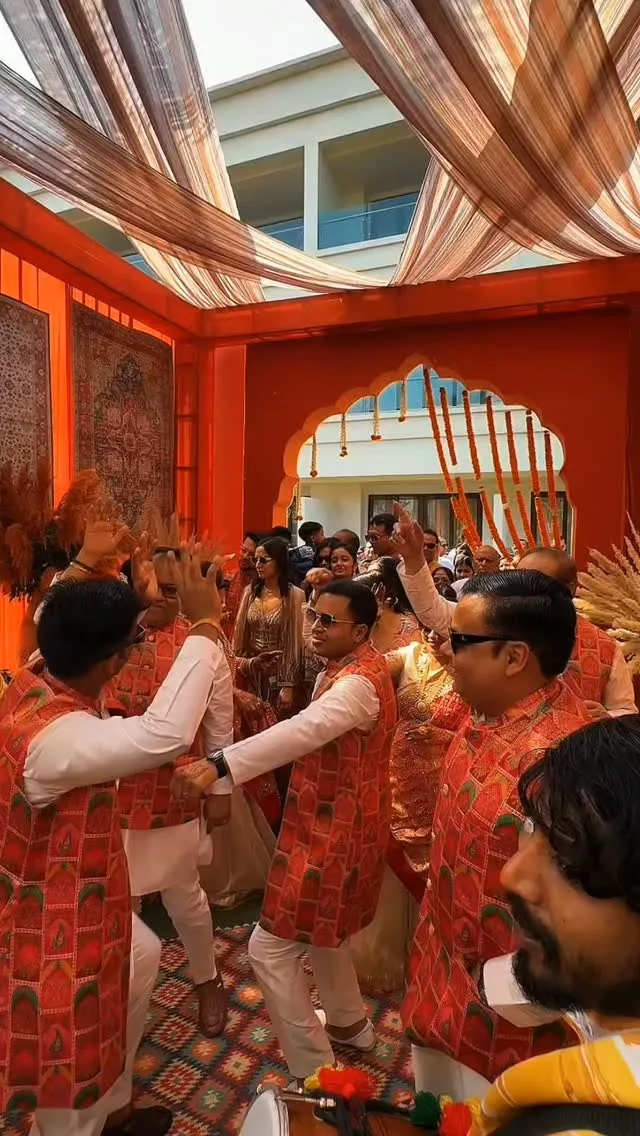 The Dramatic Company, a Gloo venture, filming guests dancing at a sangeet under an orange canopy